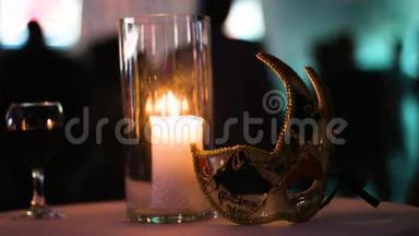 一个杯子里的蜡烛，一杯红酒，还有一个狂欢留在俱乐部的桌子上，人们